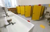 bathroom-with-many-stalls-sinks-and-yellow-doors-web.jpg